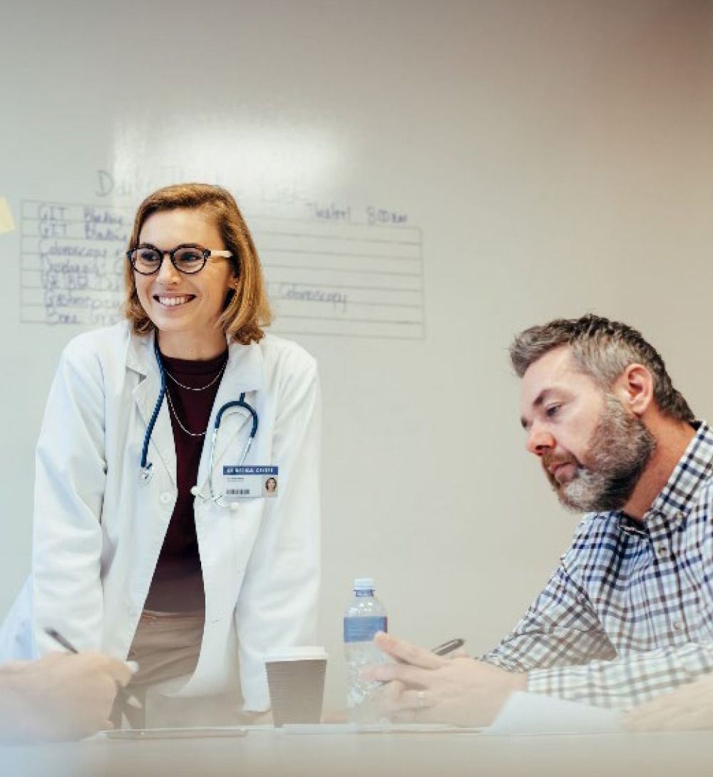 Doctor Wearing White Coat in meeting with colleagues